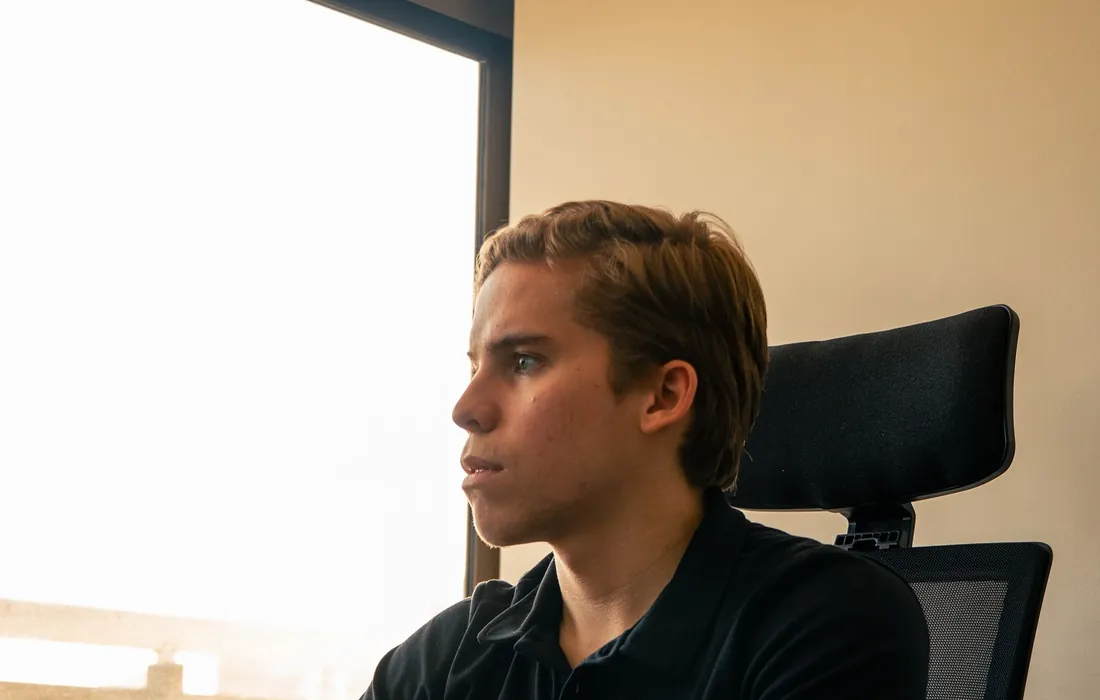 Felipe Freitas de perfil na mesa do escritório, com a camisa da Lead Land